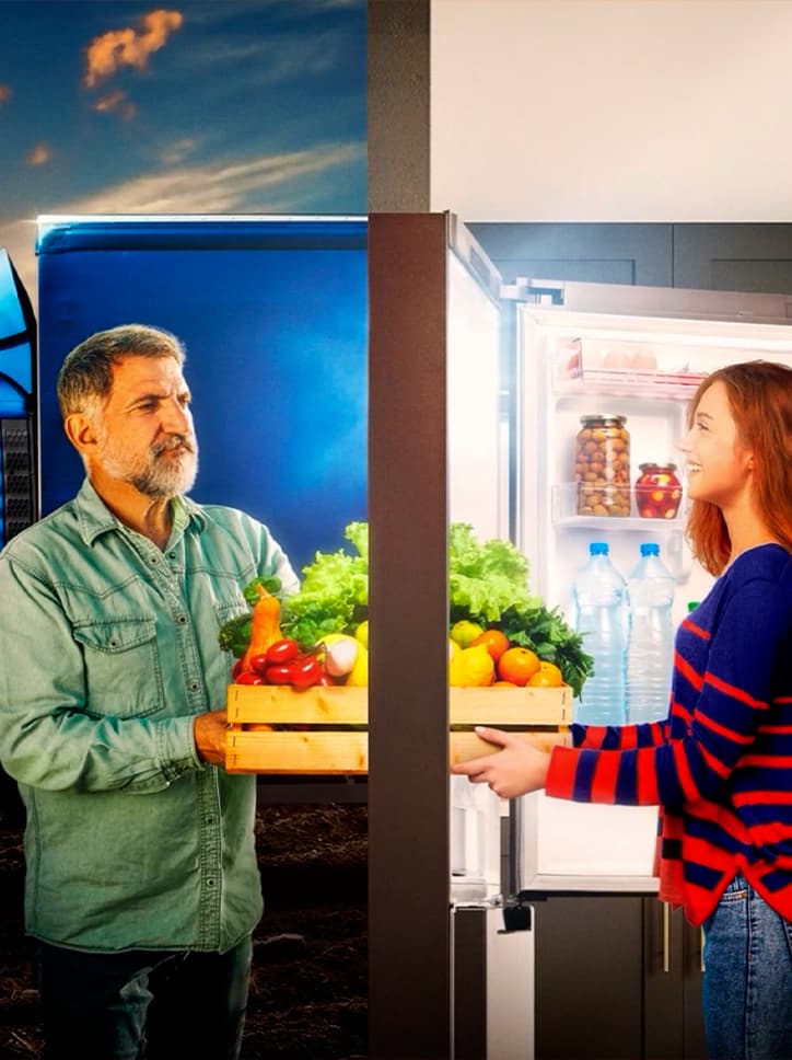 Peça da campanha "Amor que vem da terra", ilustrando o conceito "do campo à mesa" com uma montagem mostrando um agricultor entregando vegetais a uma consumidora.