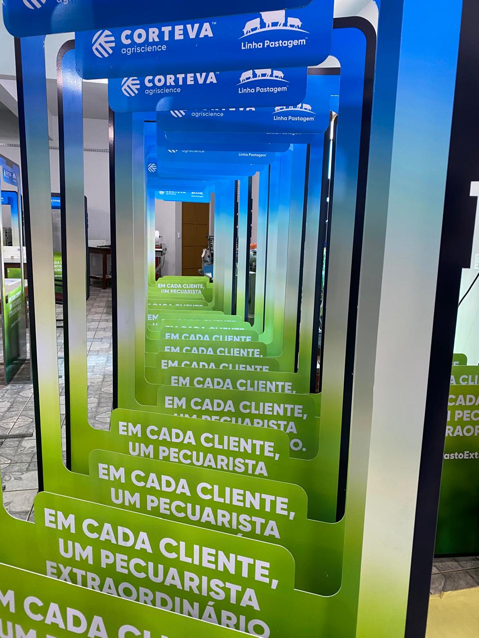 Displays publicitários da Corteva Agriscience e da Linha Pastagem, enfileirados com a frase "Em cada cliente, um pecuarista, um extraordinário".